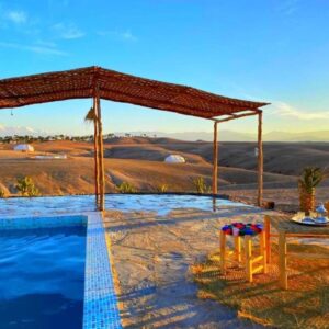 Client profitant de la piscine Agafay avec vue sur les collines désertiques