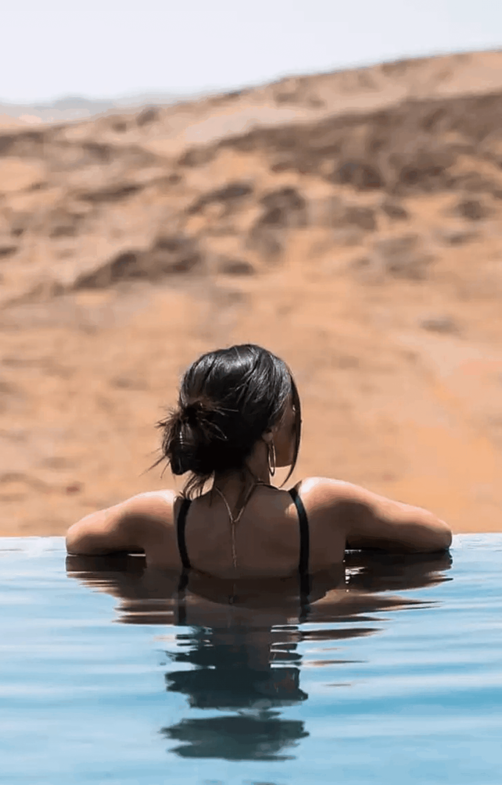 Vue panoramique de la Piscine Agafay avec palmiers et désert en arrière-plan
