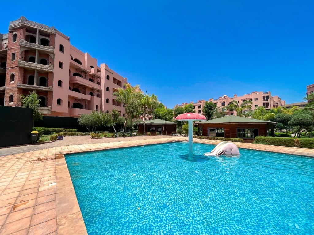Transats au bord d’une piscine panoramique avec palmiers à Marrakech