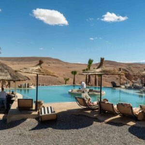 Transats confortables au bord de la piscine Agafay sous le soleil marocain