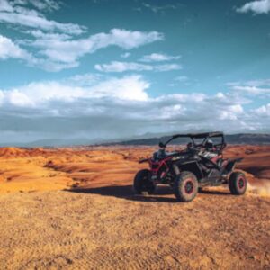 Horizon infini du désert d’Agafay avec buggys au loin